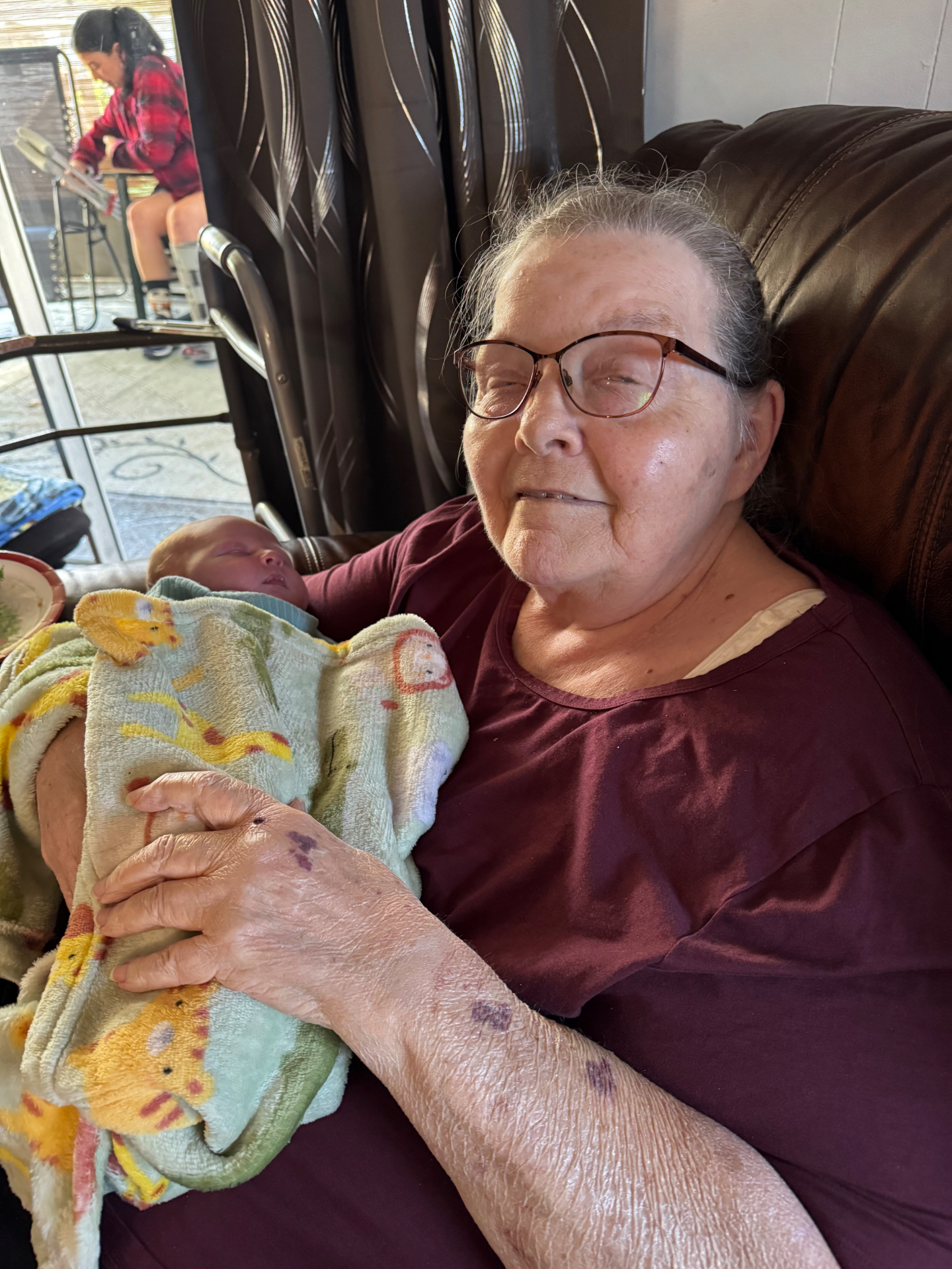 Anita's mom holding a baby wrapped in a handmade blanket